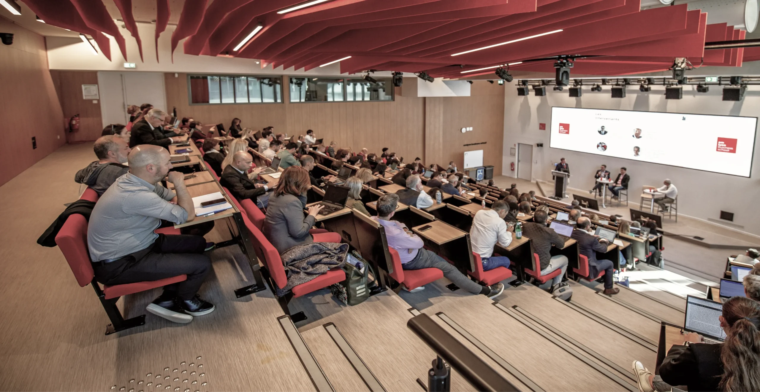 Le public assiste à une conférence dans un auditorium des Entretiens Jacques Cartier.